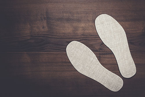 grey insoles for shoes on wooden background